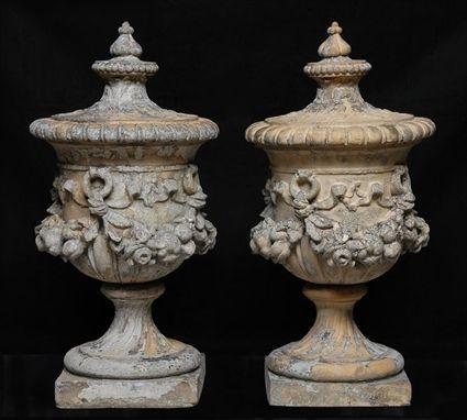 Appraisal: PAIR OF ORNAMENTAL TERRACOTTA URNS With fruited swags on fluted