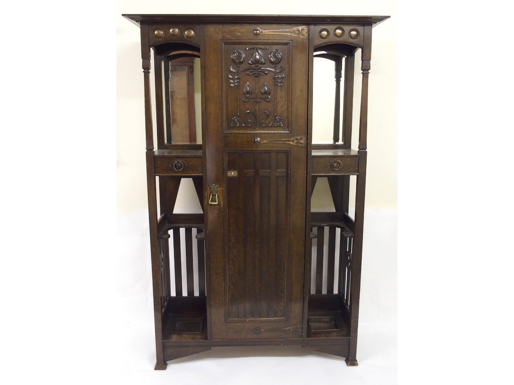 Appraisal: An Arts and Crafts oak hall cupboardthe central hinged door