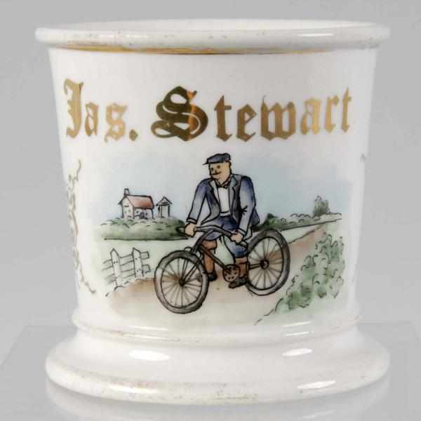 Appraisal: Man Riding Bicycle Scene Shaving Mug Description Gilt name Jas