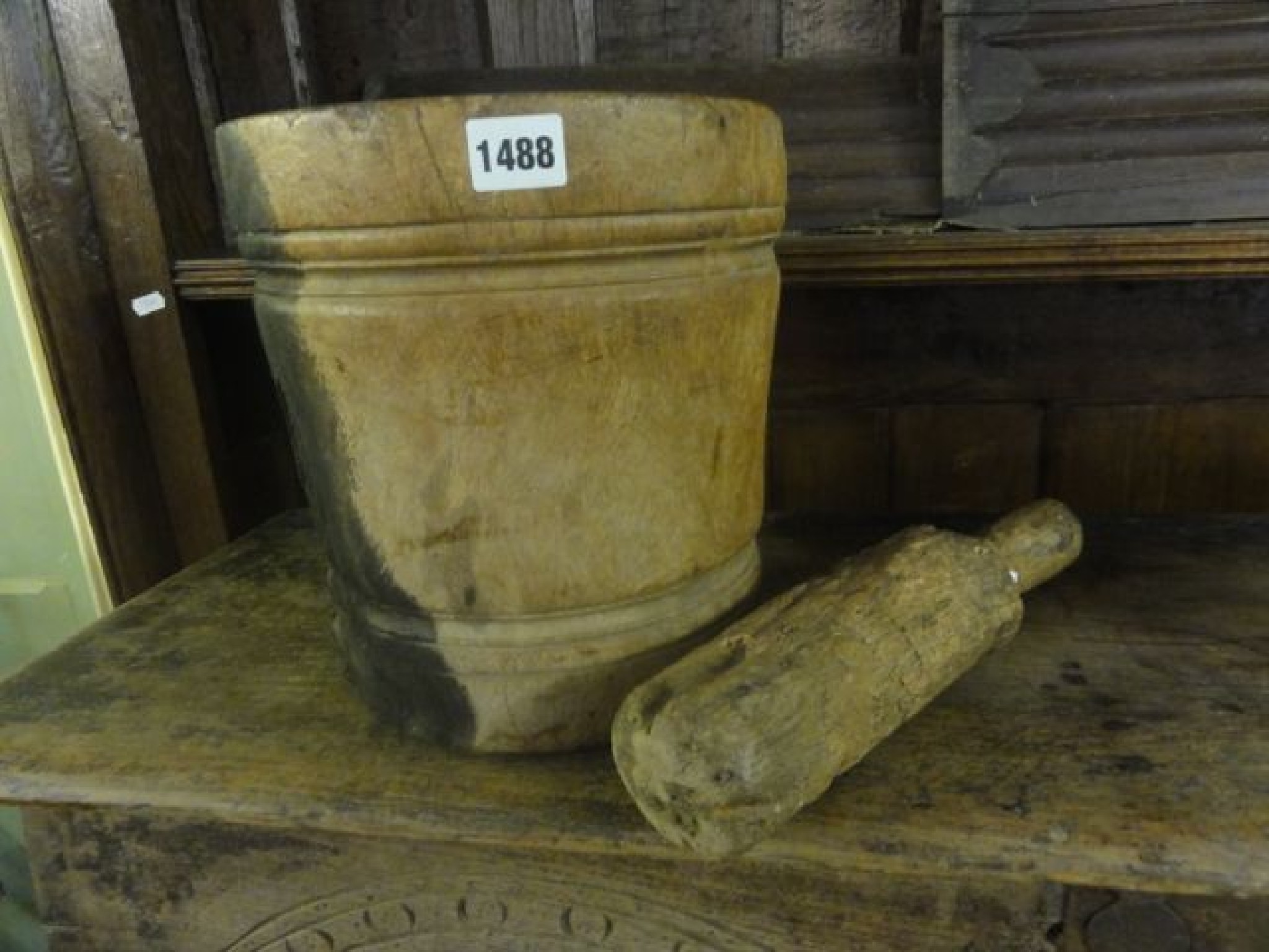 Appraisal: A primitive wooden pestle and mortar with moulded detail