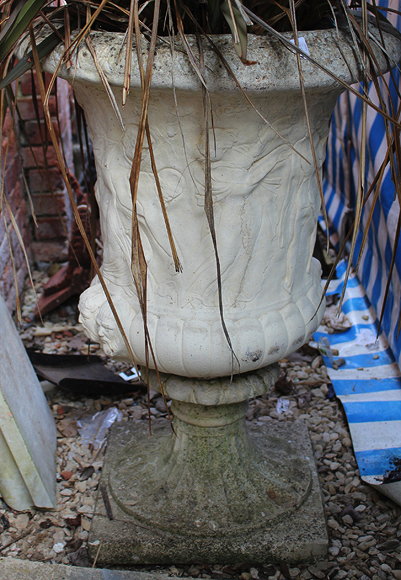 Appraisal: A PAIR OF RECONSTITUTED STONE URNS of Campana form decorated