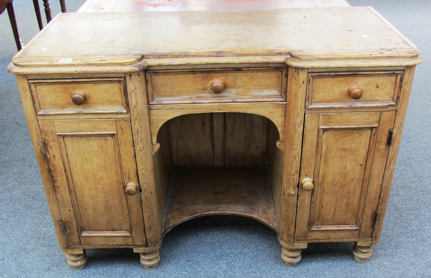 Appraisal: A Victorian pine inverted breakfront desk with three drawers and