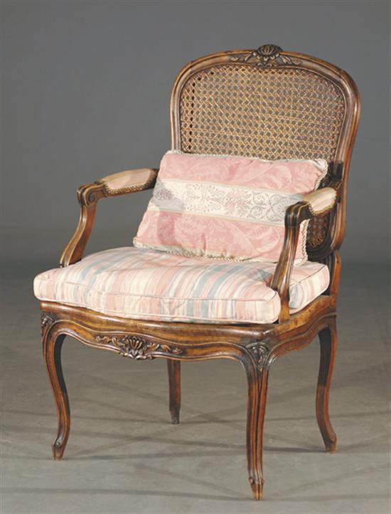 Appraisal: Louis XV style carved fruitwood and cane fauteuil bead-and-channel frame