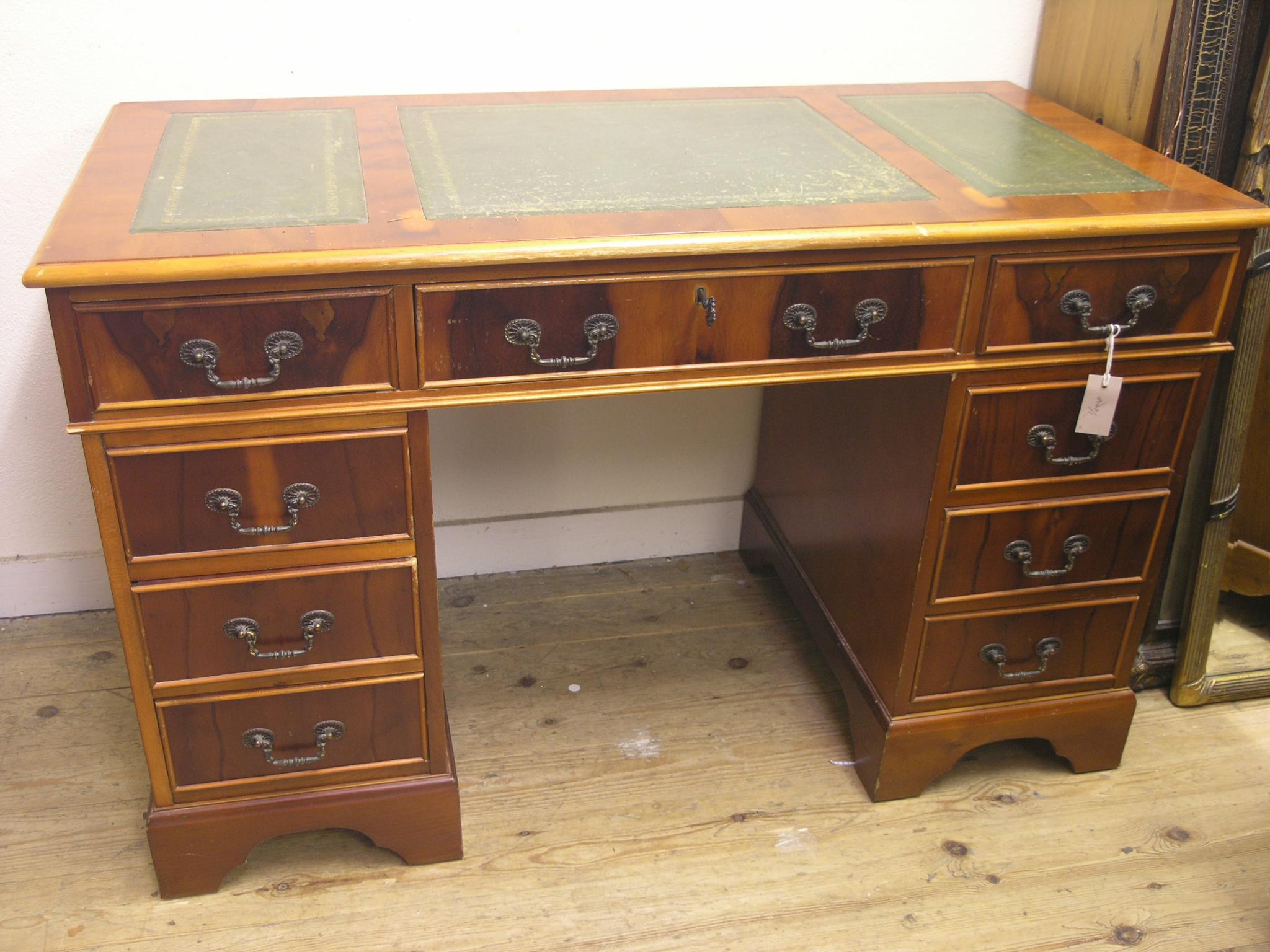 Appraisal: A reproduction yew-veneered desk inset gilt-tooled leather top with three