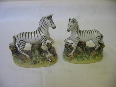 Appraisal: A PAIR OF STAFFORDSHIRE POTTERY ZEBRAS modelled standing on oval