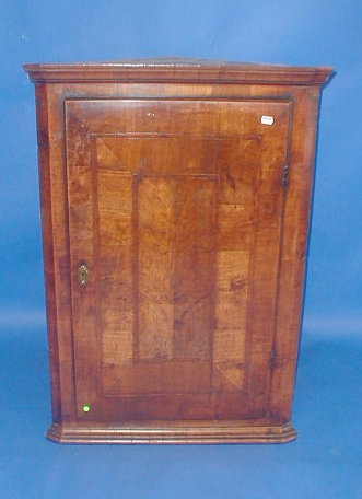 Appraisal: An thC walnut cross banded hanging corner cupboard with single