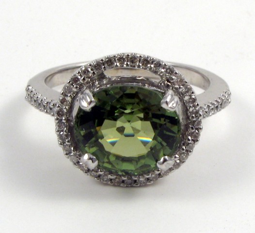 Appraisal: PERIDOT DIAMOND AND FOURTEEN KARAT GOLD RING centering an oval-cut