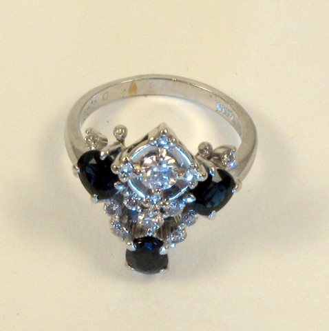 Appraisal: SAPPHIRE DIAMOND AND PLATINUM RING set with three oval-cut dark