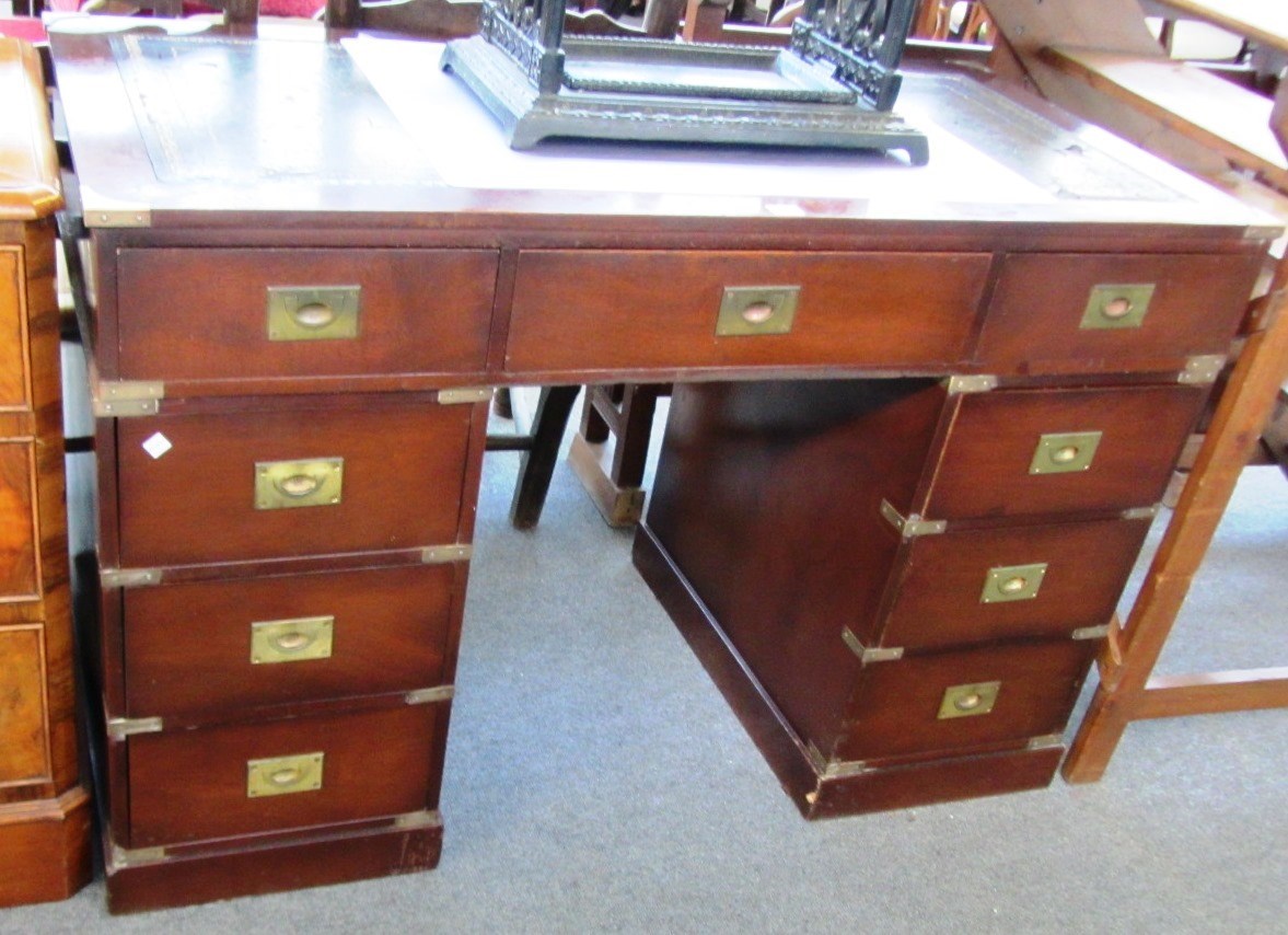 Appraisal: A campaign style brass bound mahogany pedestal desk with nine