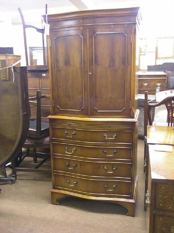 Appraisal: A yew veneered cocktail cabinet serpentine fronted having a pair