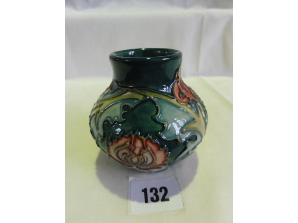 Appraisal: A small Moorcroft green ground vase with stylised pink lily