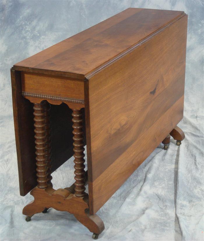 Appraisal: Walnut Victorian gateleg table with spool legs with a swing