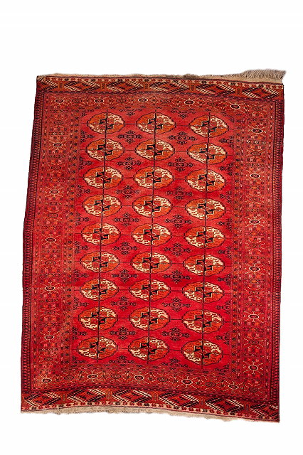 Appraisal: A TEKKE BOKHARA MID RED GROUND RUG with three rows