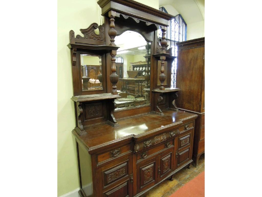 Appraisal: A substantial Edwardian walnut sideboard the raised back incorporating bevelled