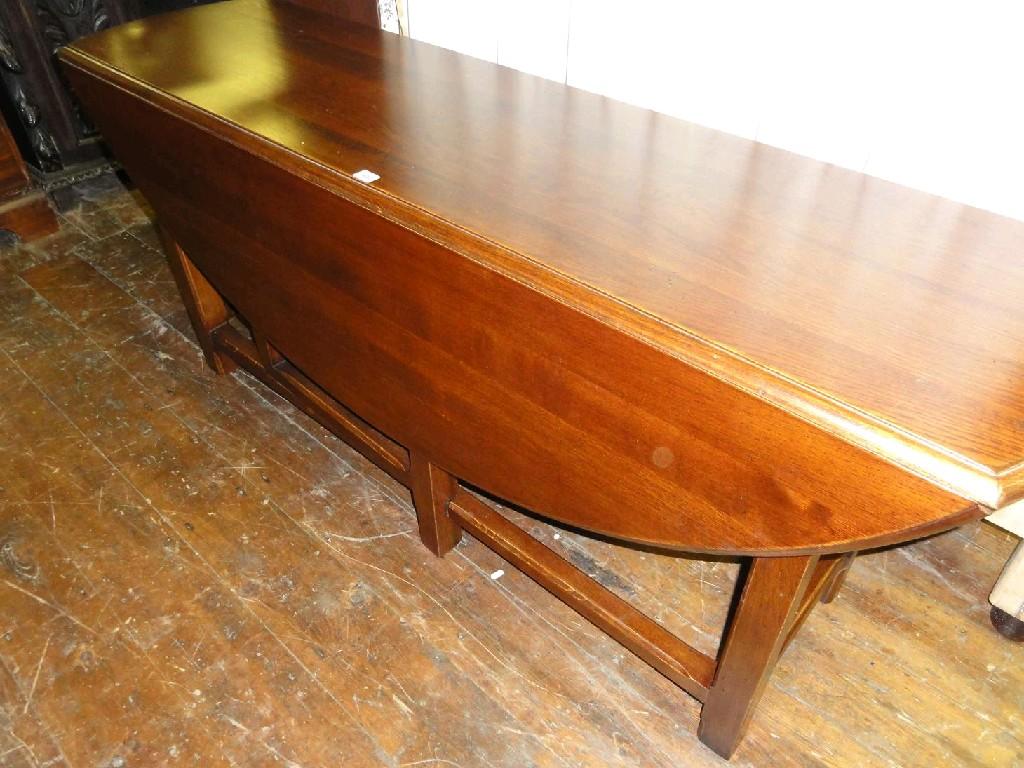 Appraisal: A reproduction oak wake table with oval drop leaves and