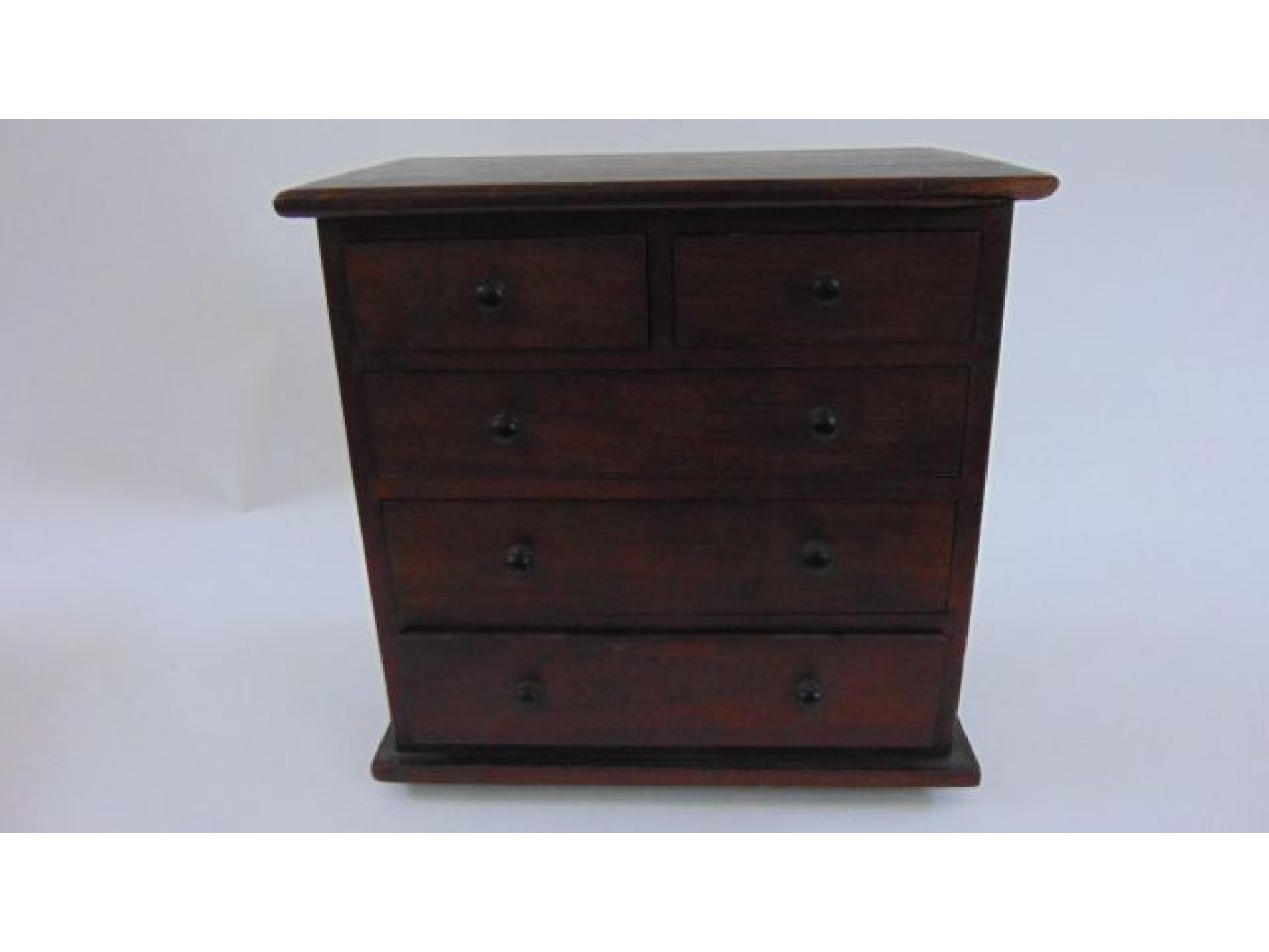 Appraisal: A miniature mahogany chest of three long and two short