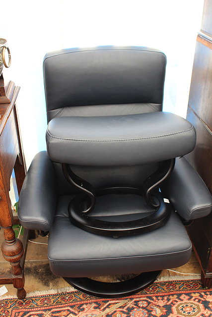 Appraisal: A PAIR OF BLACK LEATHER UPHOLSTERED STRESSLESS RECLINING ARMCHAIRS on