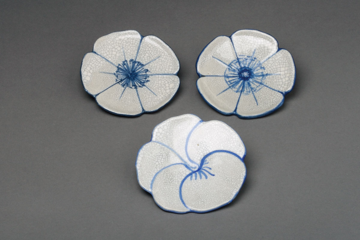 Appraisal: THREE DEDHAM POTTERY 'WILD ROSE' PATTERN BUTTER PATS Each defi