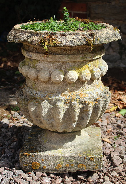 Appraisal: A CARVED STONE URN of cylindrical form with fluted base