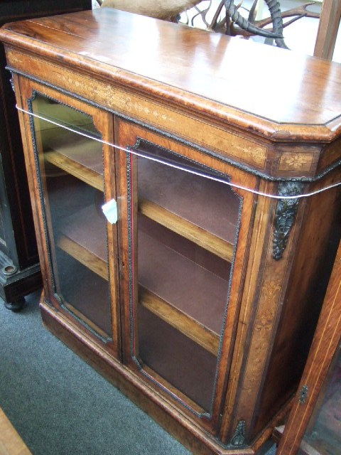 Appraisal: A Victorian walnut and inlaid glazed cabinet with brass embellishments