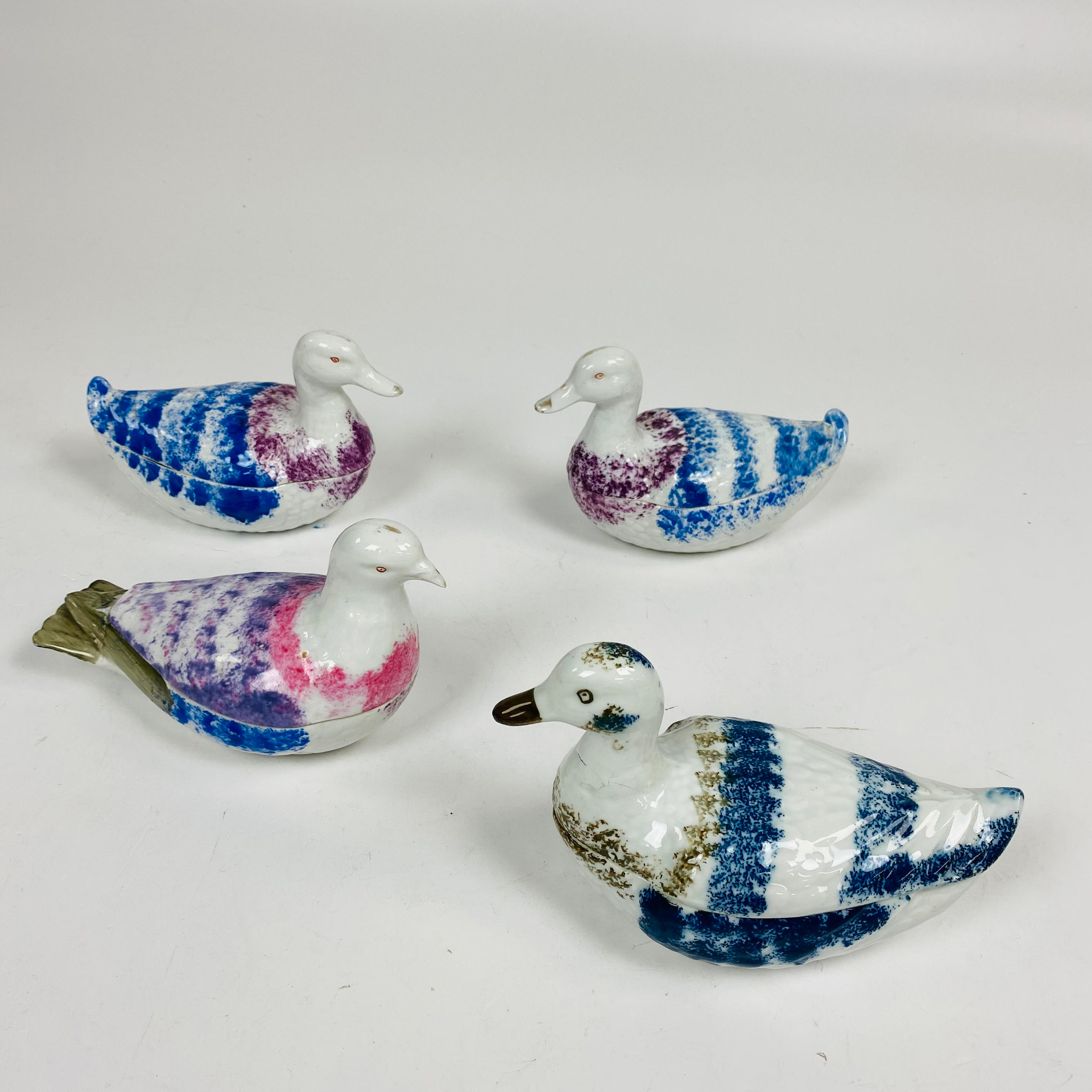 Appraisal: FOUR SPONGE-DECORATED BIRD-FORM CERAMIC SAUCEBOATS decorated in shades of purple