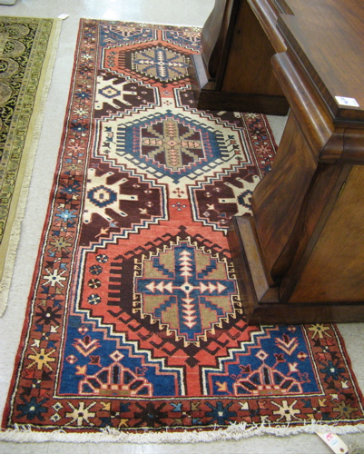 Appraisal: PERSIAN TRIBAL HAMADAN HALL CARPET geometric medallion and half-medallion design