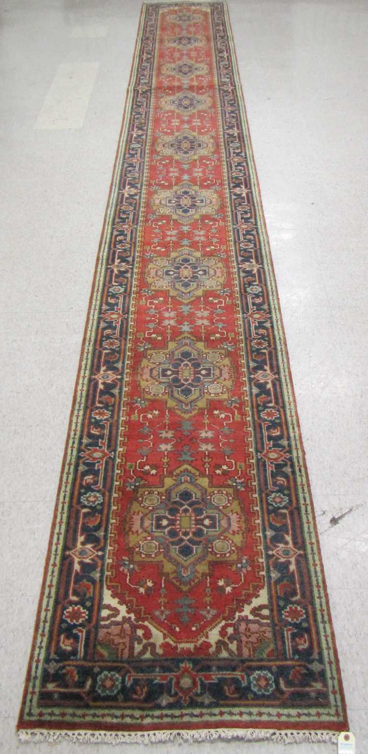 Appraisal: HAND KNOTTED ORIENTAL LONG RUG Indo-Persian featuring nine geometric medallions