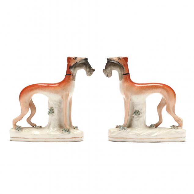 Appraisal: A PAIR OF STAFFORDSHIRE WHIPPETS th century each modeled carrying