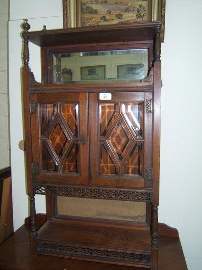 Appraisal: A mahogany wall shelf with pierced designs and bevelled glass