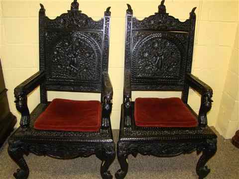 Appraisal: PAIR OF INDIAN BLACK PAINTED RELIEF CARVED ARMCHAIRS each arched