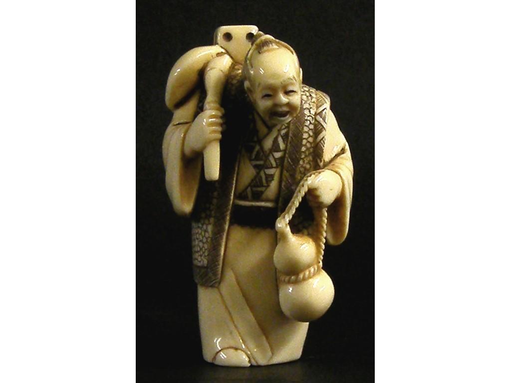 Appraisal: Japanese ivory netsuke modelled with a elderly man carrying a