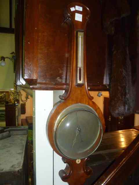 Appraisal: A VICTORIAN WALNUT WHEEL BAROMETER with brass dial shaped decoration