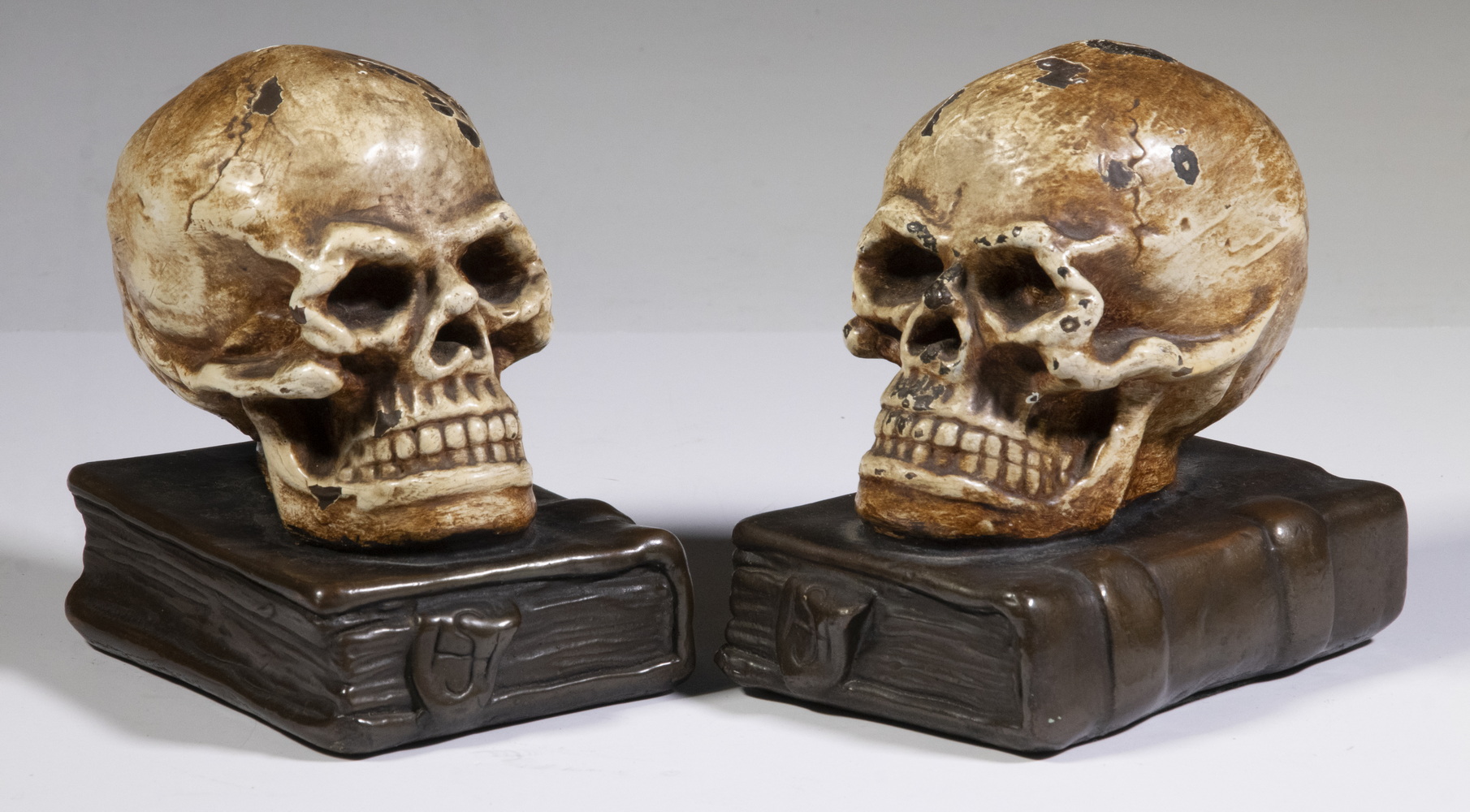 Appraisal: PR ARMOR BRONZE SKULL ON BOOKS BOOKENDS Pair of Early