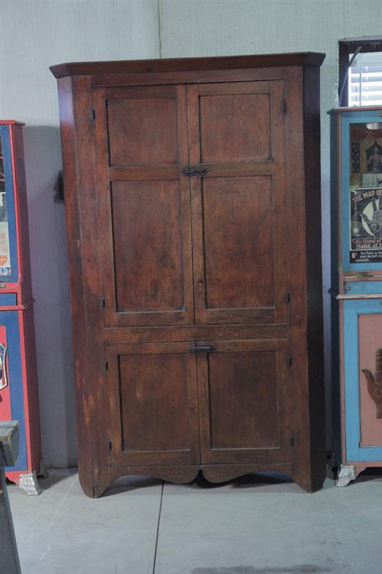 Appraisal: ONE PIECE CORNER CUPBOARD Walnut with large paneled doors and