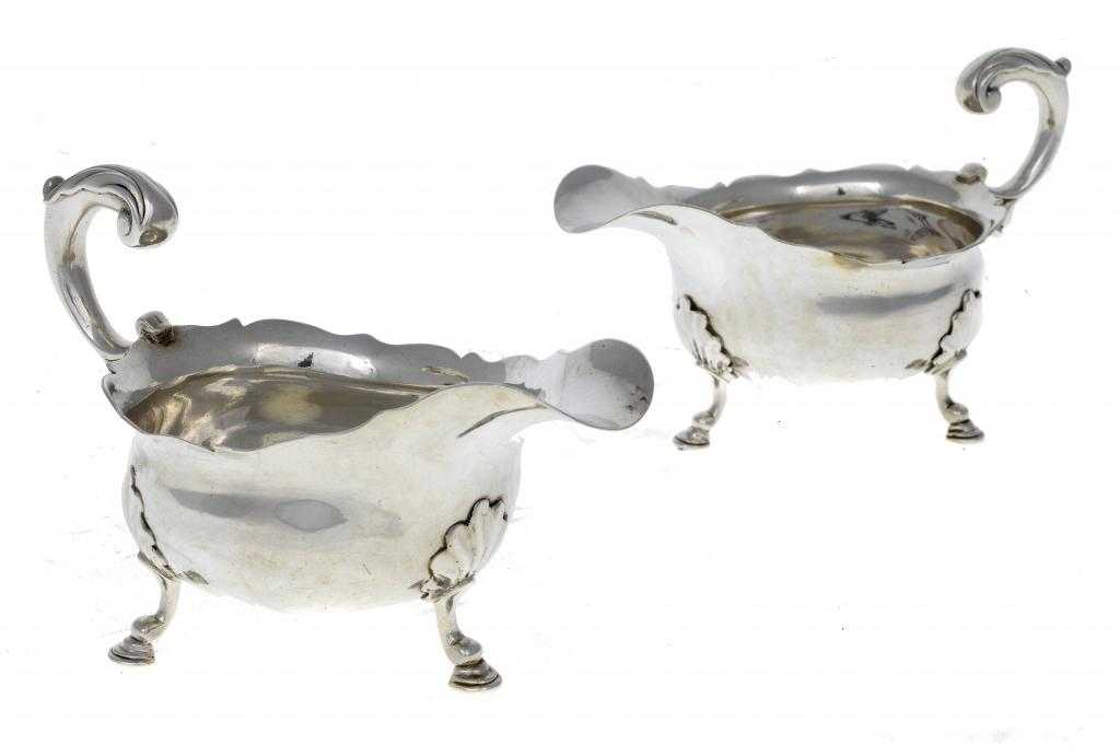 Appraisal: TWO GEORGE II SAUCE BOATS with acanthus capped flying scroll