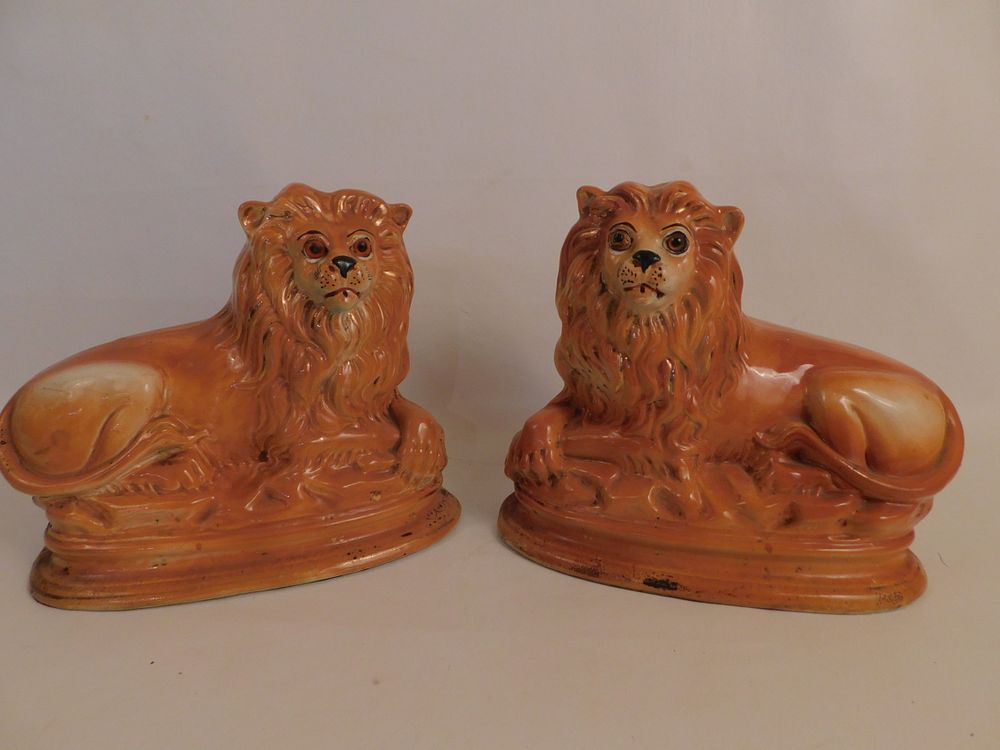 Appraisal: PAIR STAFFORDSHIRE LION FIGURINES Pair antique Staffordshire ceramic recumbent lion