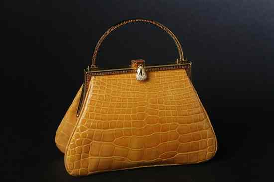 Appraisal: JUDITH LEIBER OCHRE ALLIGATOR HANDBAG Triangular with rhinestone inlaid gold-tone