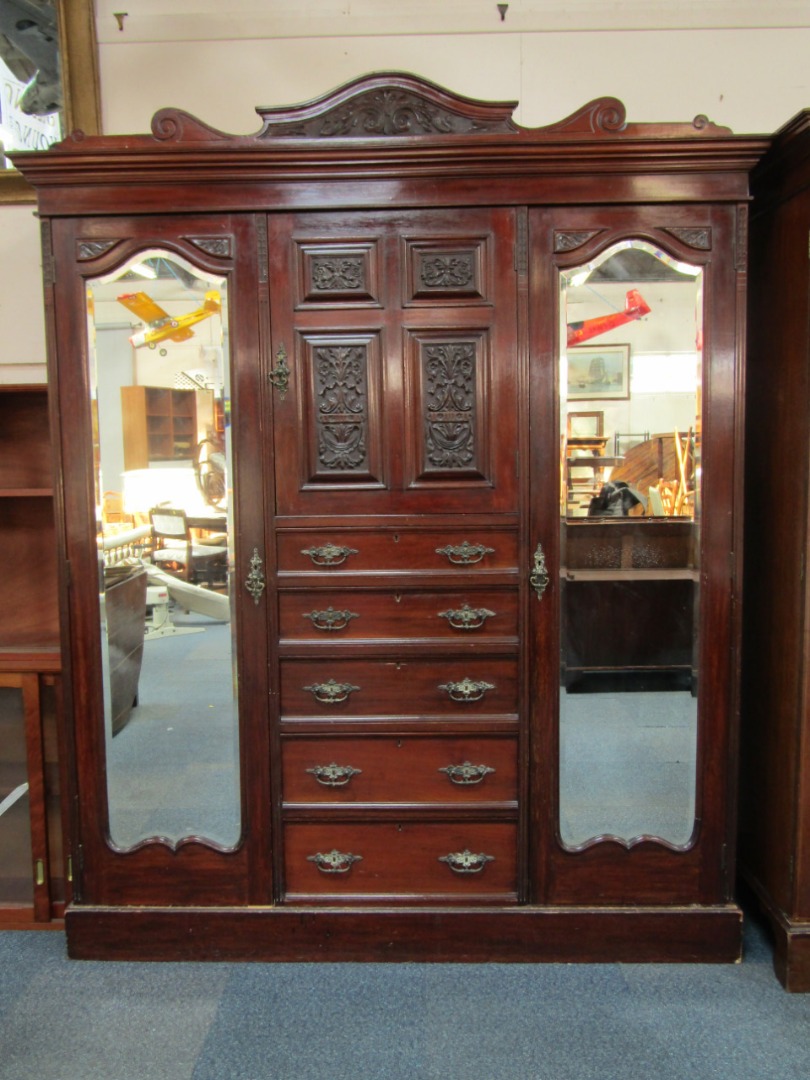 Appraisal: A Victorian mahogany compactum wardrobe the carved pediment over a