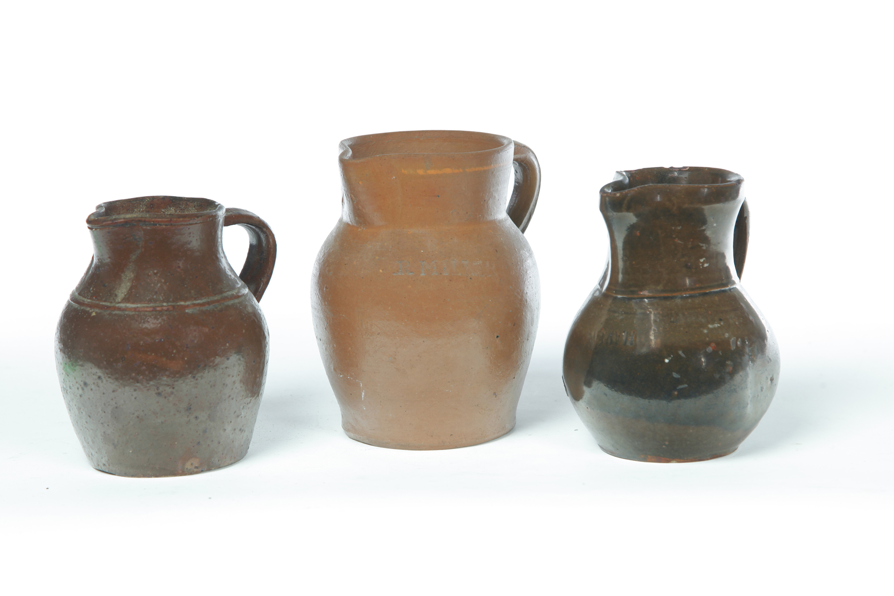 Appraisal: THREE POTTERY PITCHERS Ohio th century Of small size One