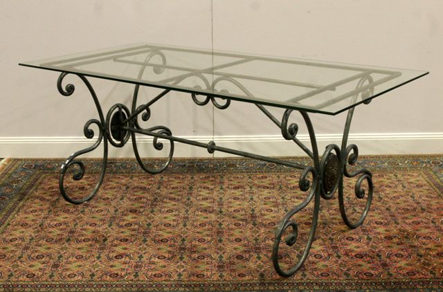 Appraisal: A scrolling forged aluminium table with glass top cm long