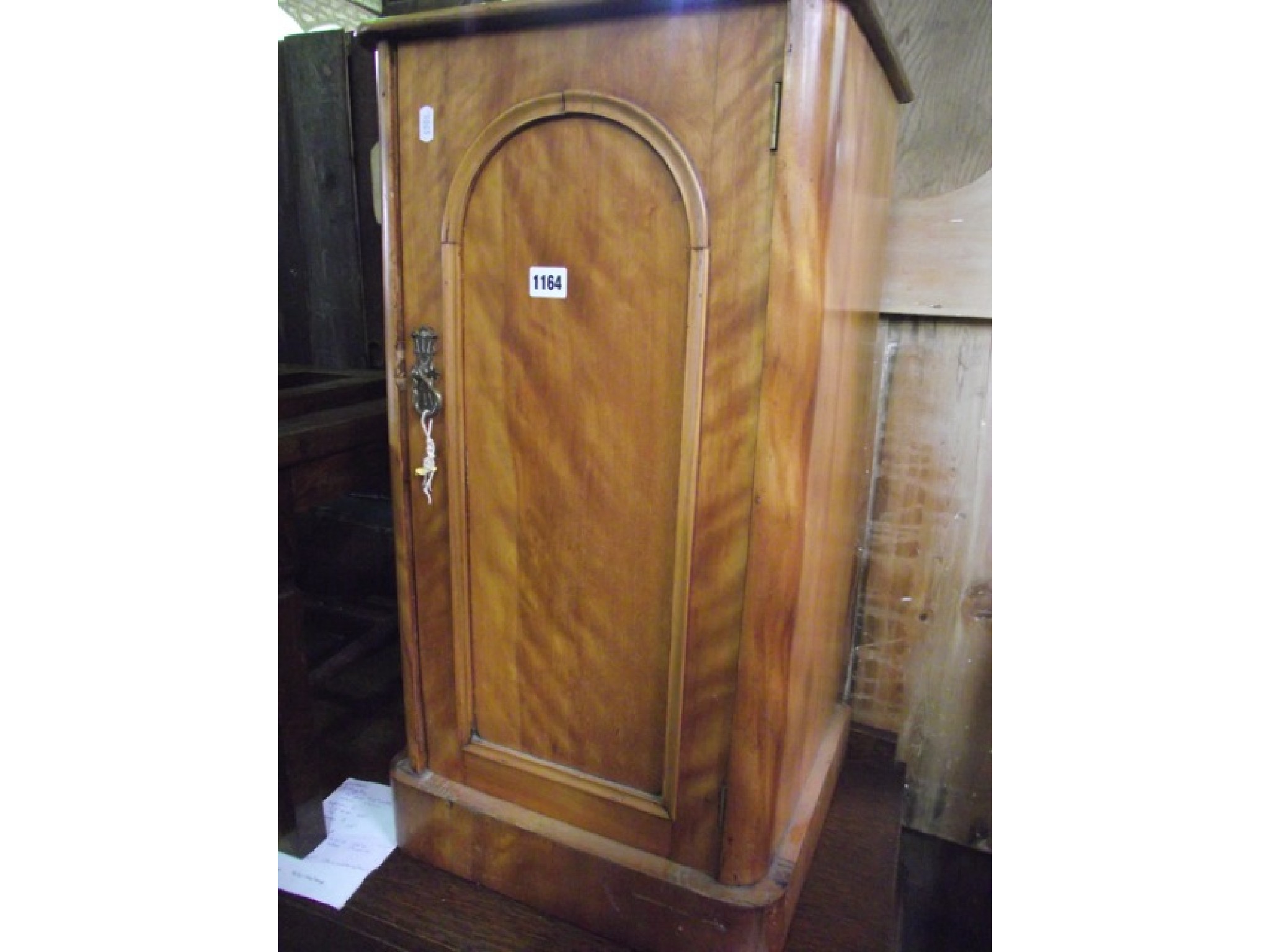 Appraisal: A Victorian satinbirch bedside cupboard enclosed by an arched moulded