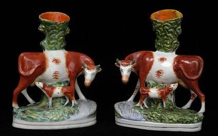 Appraisal: PAIR OF STAFFORDSHIRE COW-FORM BUD VASES Modeled as mirror images