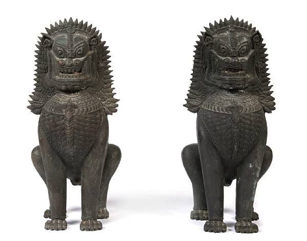 Appraisal: A pair of Southeast Asian patinated bronze crouching lion dogs