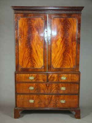 Appraisal: A flame mahogany linen press early th century the Cavetto