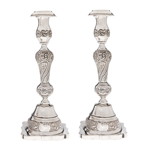 Appraisal: A pair of George V silver candlesticks nozzles cm h