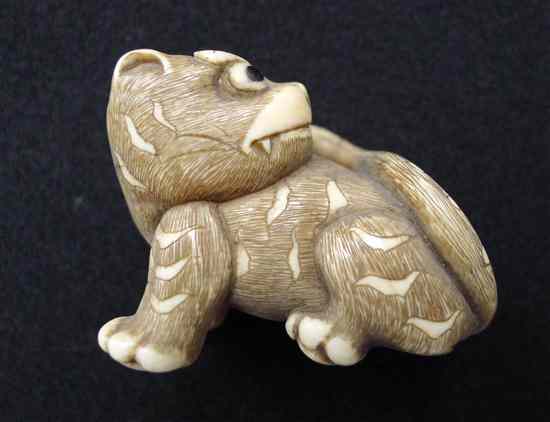 Appraisal: A stained ivory netsuke carved as a tiger with horn