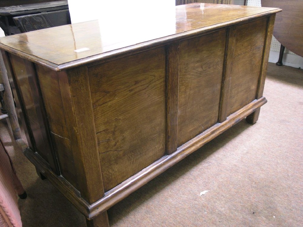 Appraisal: A solid panelled oak coffer with boarded top on stile