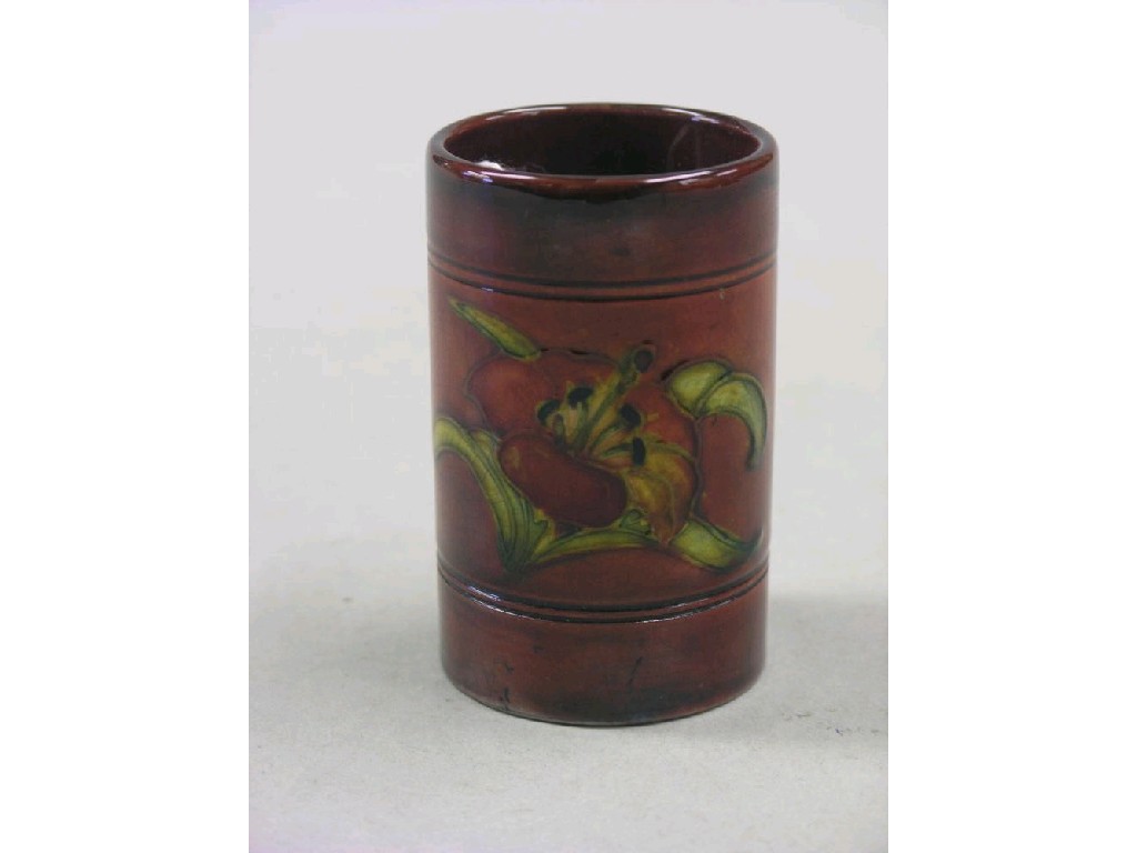 Appraisal: A Moorcroft spill vase cylindrical shape painted with a flambe