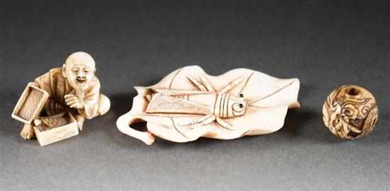 Appraisal: Two Japanese carved ivory netsukes and a carved ivory Ojime