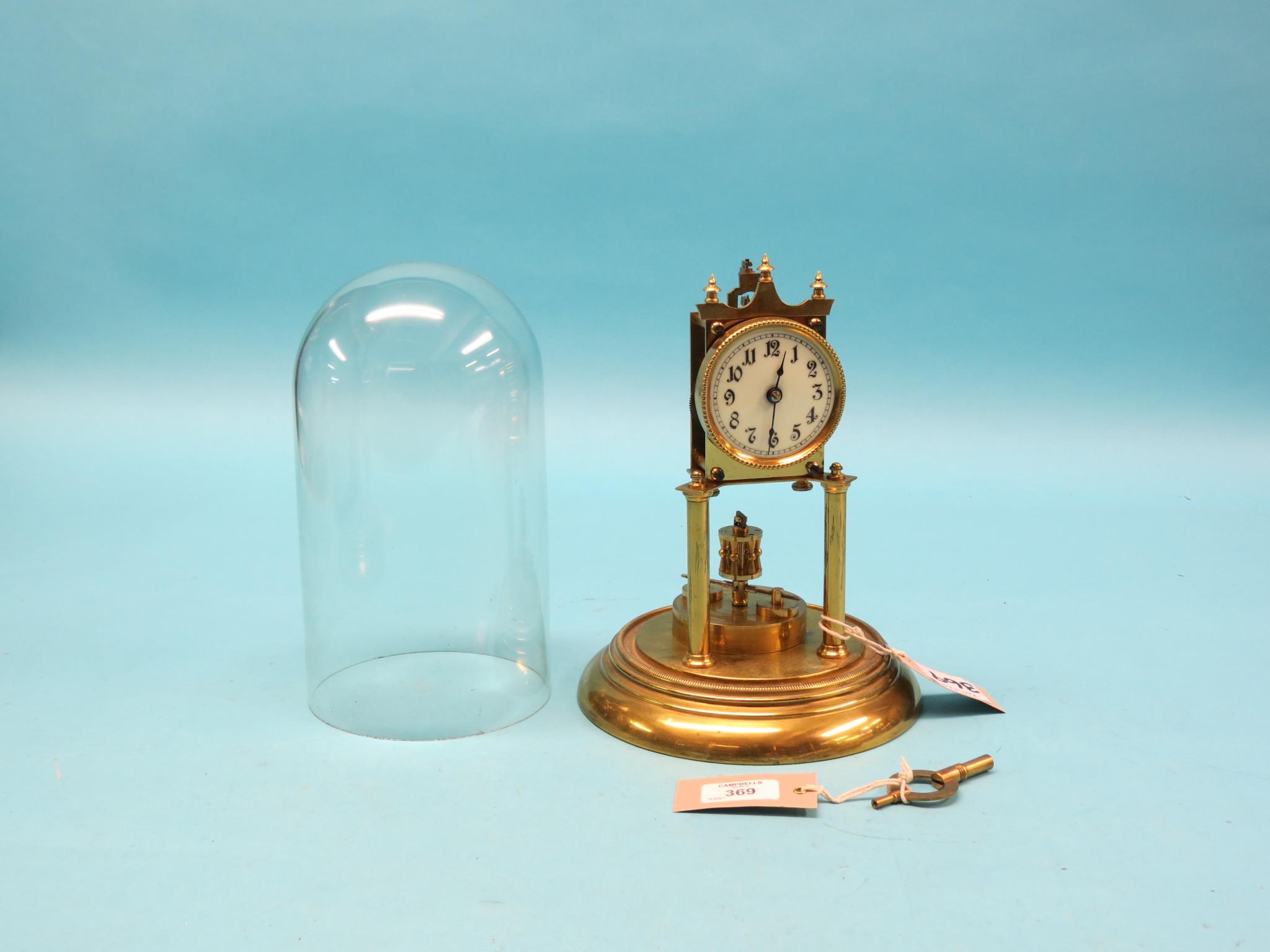 Appraisal: A brass long-duration mantel clock on circular brass plinth under